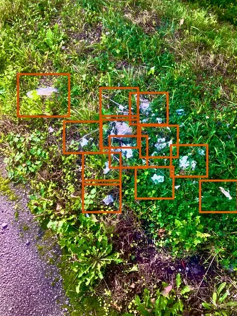 Épareuse fauchant un accotement routier jonché de déchets plastiques